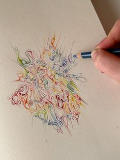 a person is drawing with colored pencils on paper that has been drawn in different colors