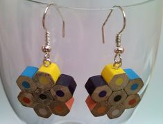 a pair of earrings made out of colored pencils