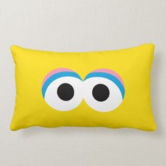 a yellow pillow with two eyes and one eyeball on the front, which is drawn in