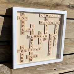 a scrabbled wooden frame with words written in it on wood planks