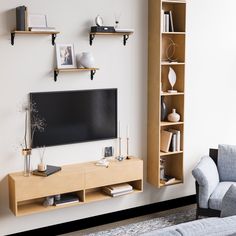 a living room filled with furniture and a flat screen tv mounted on a wall next to a couch