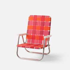 an orange and pink plaid lawn chair against a white background, with the seat up