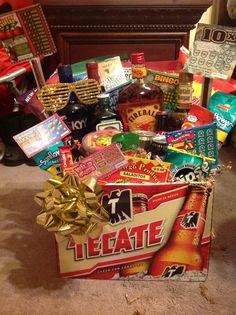 a box filled with lots of different types of liquor and candy bars on top of a carpeted floor