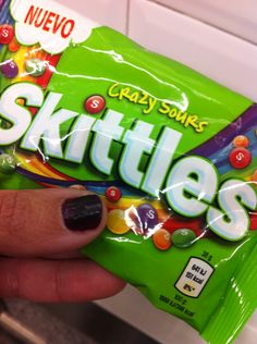 a person holding a bag of skittles in their hand