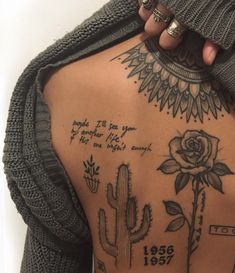 the back of a woman's body with tattoos on it