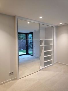 an empty room with white walls and glass doors