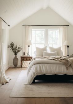 a bedroom with white walls and wooden floors