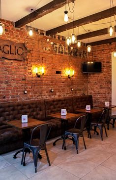 an empty restaurant with brick walls and tables