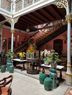 the inside of a building with many tables and vases