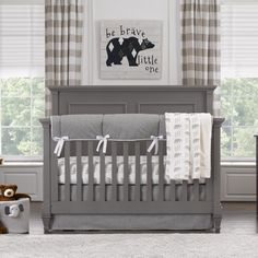 a baby crib with two teddy bears in the corner and curtains on the window