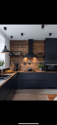 an image of a modern kitchen setting with black cabinets and wood paneling on the walls