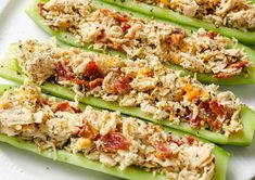 four stuffed green peppers on a white plate