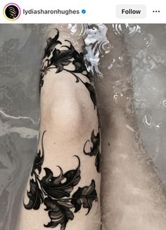 a woman's foot with black flowers on it