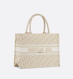 Introduced by Maria Grazia Chiuri, Creative Director of Christian Dior, the Dior Book Tote has become a staple of the Dior aesthetic. Designed to hold all the daily essentials, the style is fully embroidered with a white and gold-tone Dior Oblique motif and is further adorned with the Christian Dior Paris signature on the front. The medium tote exemplifies the House's signature savoir-faire and may be carried by hand or worn over the shoulder.. Christian Dior Bag, Dior Aesthetic, Dior Book, Christian Dior Paris, Dior Paris, Dior Oblique, Book Tote Bag, Dior Book Tote, Maria Grazia Chiuri