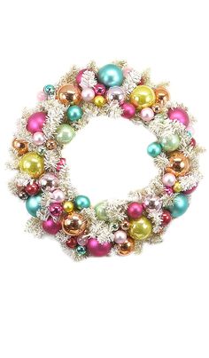 a christmas wreath with multicolored ornaments and tinsels on the front, against a white background