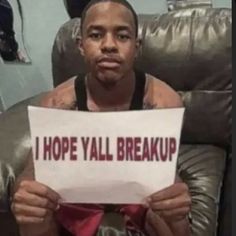 a man sitting in a chair holding a sign that says i hope yall break up