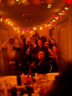 a group of people standing around each other in a room with lights on the ceiling