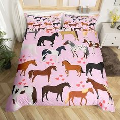 a pink bed with horses on it and hearts in the shape of heart - shaped shapes