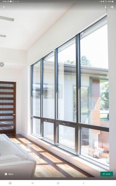 a living room with white furniture and large windows