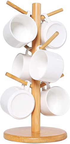 a wooden stand with white cups and saucers on it's sides, all stacked together