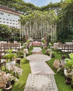 an outdoor ceremony setup with wicker chairs and rugs on the grass, surrounded by trees