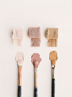 there are five brushes with different shades of paint on them, one is pink and the other is brown