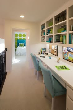 a home office with white desk and blue chairs