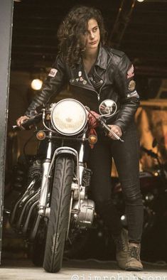 a woman sitting on top of a motorcycle