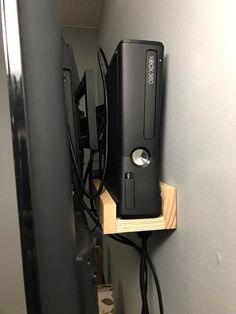 a black computer on a wooden shelf in a room