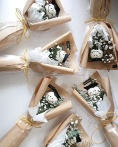 six wrapped gift bags with snowmen and flowers in them, tied together to each other