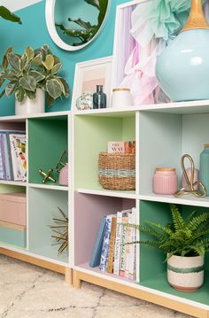 the shelves are filled with books, plants and other decorative items in pastel colors