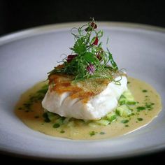 a white plate topped with fish covered in sauce