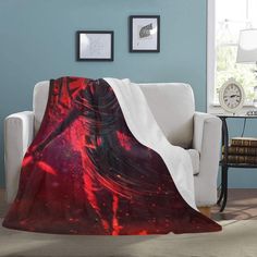 a red and black blanket on a couch in a living room with a white chair