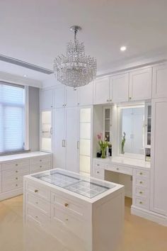 an empty room with white cabinets and a chandelier