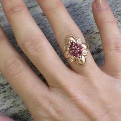 This vintage statement ring is made of 18K yellow gold. Set in the center are nine round and oval shaped rubies in various shades of pink and red. These rubies create a floral motif with four round diamonds at each corner point. The scalloped edge of the center ring with the thin band gives this ring a delicate touch.Metal: 18K Yellow GoldRubies: .83 CTW ApproximateDiamonds: .04 CTWWidth: 22.5 MMSize: 5.75 If you have any questions about this product or if we can help you with any of our other p Vintage Ruby Wedding Rings, Art Deco Ruby Engagement Ring, Antique Ruby Ring, Unique Jewelry Vintage, Ruby Wedding Rings, Unusual Engagement Rings, Ruby And Diamond Ring, Ruby Diamond Rings, Ruby Engagement Ring