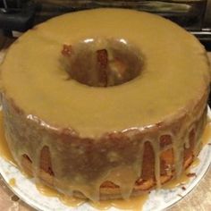 a cake sitting on top of a white plate covered in icing and drizzle