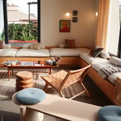 a living room filled with lots of furniture and large windows overlooking the outdoors area in front of it