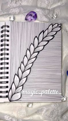 a spiral notebook with an image of a plant on the cover and some beads around it