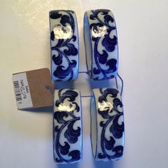 four blue and white vases sitting on top of a table next to a tag