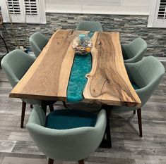 a wooden table with blue chairs around it and a bowl on the center piece that is made out of wood