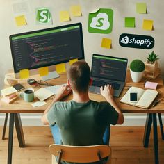 a man sitting at a desk with two computer monitors