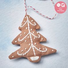 an ornament shaped like a christmas tree hanging from a string on a blue background