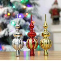 three christmas ornaments sitting on top of a wooden table