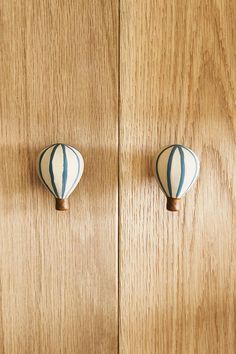 two white and blue hot air balloons on wooden doors