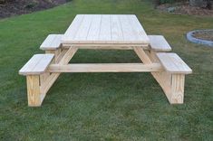 a wooden picnic table sitting in the grass