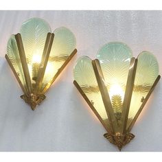 two sconces with glass shades on the wall