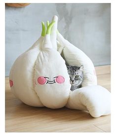 a cat hiding in a stuffed animal that is shaped like a snail with its eyes open