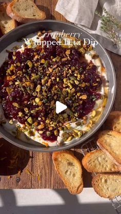 a pan filled with food sitting on top of a table next to bread and crackers