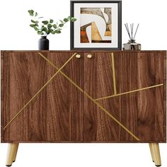 a wooden cabinet with gold lines painted on the front and sides, next to a potted plant