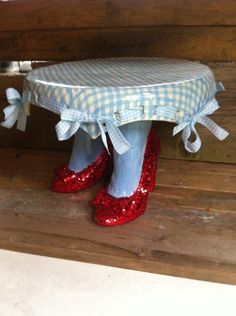 a pair of red shoes sitting on top of a wooden bench covered in sequins